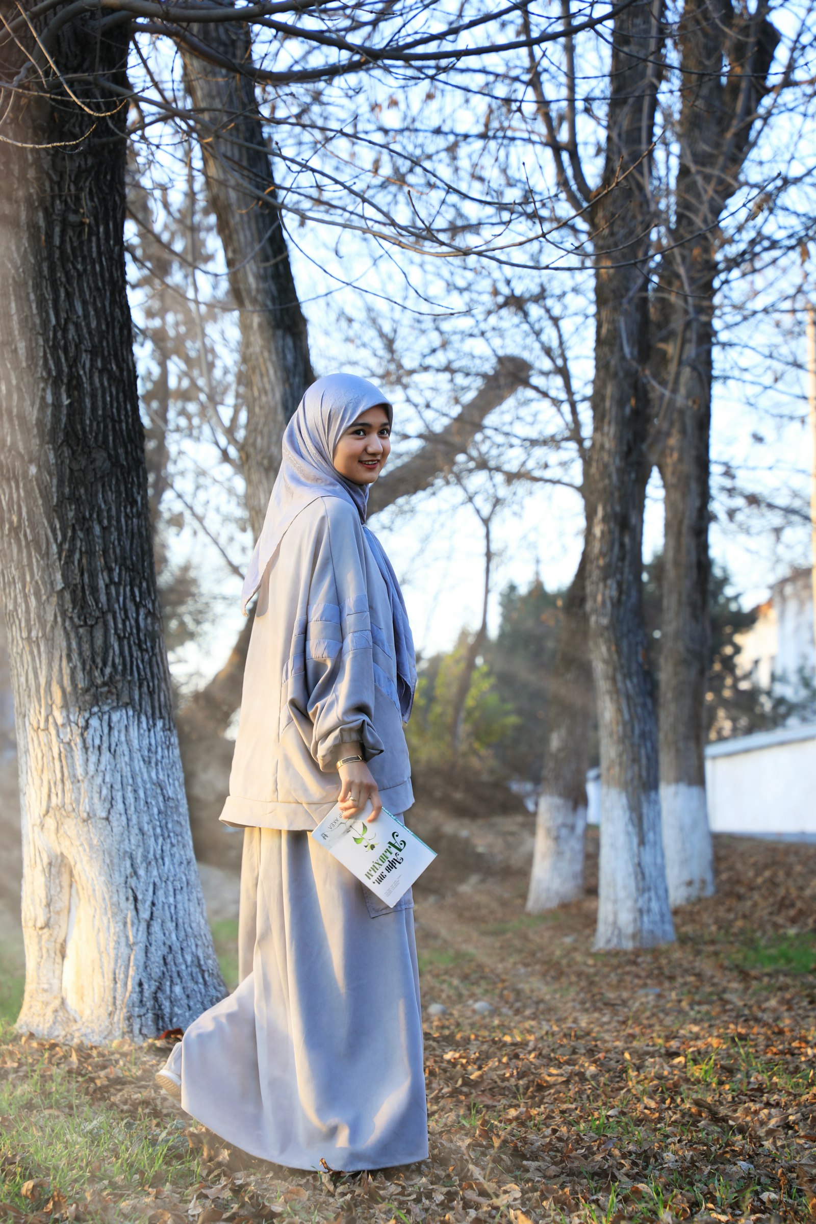 Perempuan memakai gamis dan hijab di taman