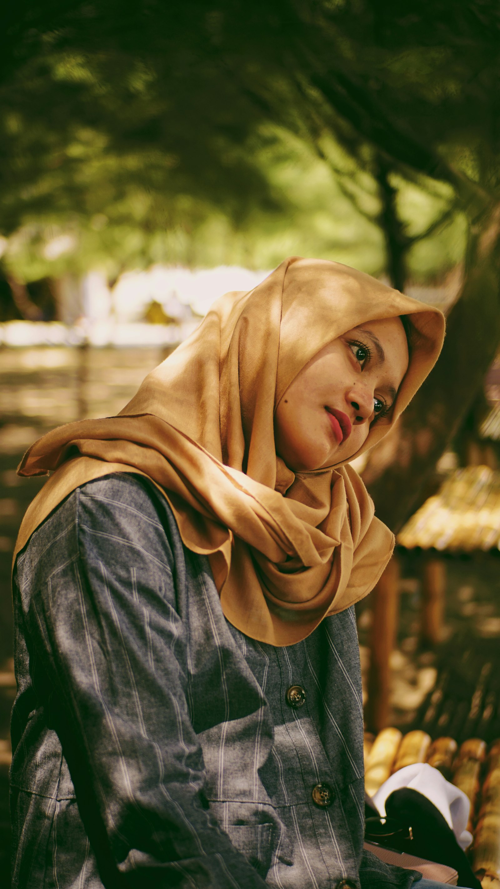 Perempuan memakai pashmina cokelat dan jaket denim